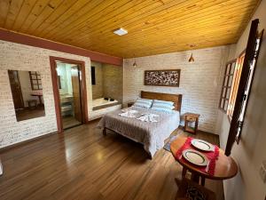 蒙特韦尔迪Pousada Requinte da Serra的一间卧室配有一张床和浴缸