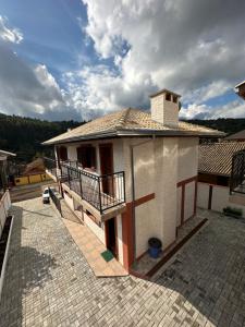 蒙特韦尔迪Pousada Requinte da Serra的带阳台的小型房屋