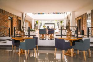 瓜塔佩Hotel La Magdalena Adult Only的一间设有两张桌子和椅子及镜子的用餐室