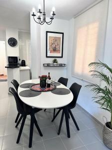 米哈斯科斯塔Art-Apart Caronte in Riviera del Sol, Mijas Costa的一间配备有白色桌子和黑色椅子的用餐室