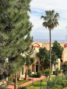 米哈斯科斯塔Art-Apart Caronte in Riviera del Sol, Mijas Costa的棕榈树和大海背景的房子