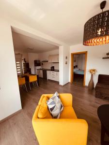 梅杜林Apartman Bijeca - Medulin的一间带黄色沙发的客厅和一间厨房