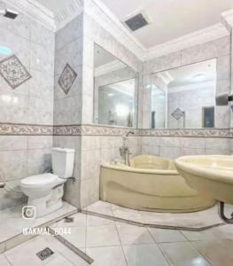 巴东Flamboyan House的带浴缸、卫生间和盥洗盆的浴室
