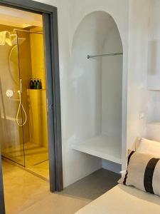 奥斯图尼MAREULIVI的一间卧室设有一张床和一个通往淋浴的玻璃门