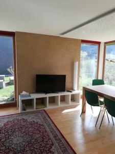 阿尔贝施文德Urlaub in Alberschwende的客厅配有电视和桌椅