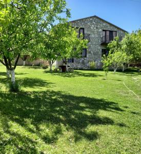伊杰万Guest house Ijevan's Garden的一座石头房子,位于一个树木繁茂的院子中间