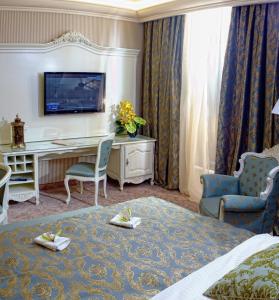 基希讷乌Savoy Hotel的酒店客房,配有一张床、一张桌子和椅子