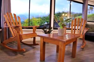 El FosforoLove Cabin - Arenal Volcano & Lake views的客厅配有两张木椅和一张桌子