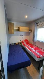 波讷地区圣朱利安Mobil-home Loic camping les Dunes de Contis的小房间设有两张床和窗户