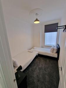 盖茨黑德Luna Apartments Newcastle Gateshead 1的小房间设有两张床和窗户