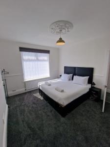 盖茨黑德Luna Apartments Newcastle Gateshead 1的卧室配有一张带白色床单的大床和窗户。