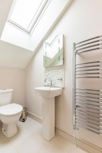 科斯特赛Woodside House的浴室配有卫生间、水槽和天窗。