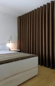 布拉加提巴斯修道院酒店的一间卧室配有床和棕色窗帘