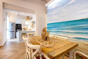 瓦雷多利亚Cuore di Sardegna的一间用餐室,配有一张桌子和一幅海洋画
