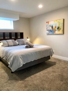 盐湖城Cozy Getaway near SLC Airport & Downtown - 1st floor Apartment的卧室配有一张大床,墙上挂有绘画作品