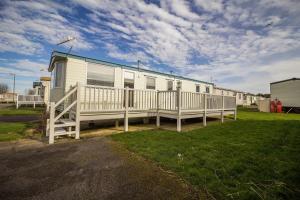 亨斯坦顿Caravan With Decking At Manor Park, Nearby Hunstanton Beach Ref 23013c的移动房屋设有门廊和围栏