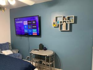 萨拉索塔Mini Studio: 10 min/Siesta Key/Private entrance/的一间设有一张桌子和一台电视的蓝色墙壁客房