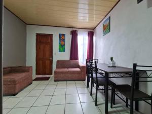 福尔图纳Apartment Guayabon #1, Arenal Volcano Fortuna的客厅配有桌子和沙发