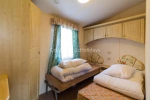 亨斯坦顿6 Berth Dog Friendly Caravan In Hunstanton, Minutes From The Beach Ref 13013l的一间卧室设有两张床和窗户。