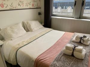 布拉加Liber Guest House的一间卧室配有一张大床和毛巾