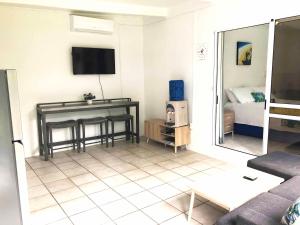 阿瓦鲁阿Avarua Escape, Rarotonga的客厅配有沙发和墙上的电视