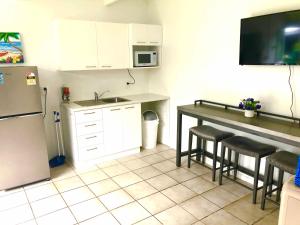 阿瓦鲁阿Avarua Escape, Rarotonga的厨房配有冰箱和带凳子的桌子