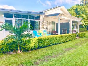 阿瓦鲁阿Avarua Escape, Rarotonga的院子里有棕榈树的房子