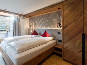 迈尔霍芬Ferienhof Oblasser的卧室配有带红色枕头的大型白色床