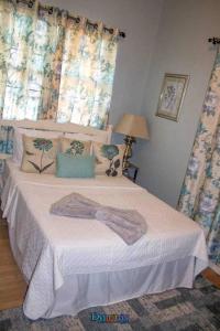 Potters VillageAdama Suites的一间卧室配有一张带白色床单和蓝色窗帘的床。