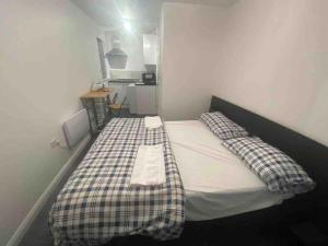 米尔顿凯恩斯Guest House in Milton Keynes的一间小卧室,配有一张带铺着地毯的床