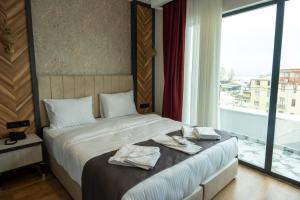 伊斯坦布尔Linda Port Hotel的一间卧室设有一张床和一个大窗户