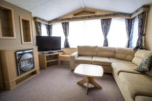 亨斯坦顿6 Berth Pet Friendly Caravan By Hunstanton Beach, Norfolk Ref 13012l的带沙发和电视的客厅