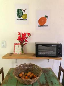 贡萨尔维斯Casa Morango Gonçalves的一张桌子,上面放着一篮水果和一台微波炉