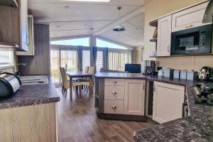 亨斯坦顿Stunning 6 Berth Lodge With Decking At Manor Park In Hunstanton Ref 23064k的一个带台面的厨房和一间餐厅