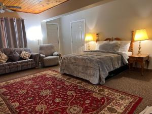 奥斯威戈Oswego Inn的一间卧室配有一张床、一张沙发和一把椅子