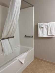 奥斯威戈Oswego Inn的白色的浴室设有浴缸和毛巾。