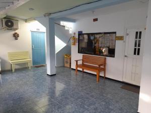 圣安德烈斯Posada Henry Sede Centro的一间带长凳和墙上电视的房间