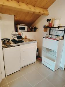 里摩日La maison blanche的厨房配有白色橱柜和白色冰箱。