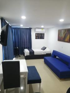 卡塔赫纳Ocean blue Ed Conquistador的客房设有两张床、一台电视和一张沙发。