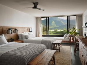 普林斯维尔1 Hotel Hanalei Bay的酒店客房设有两张床和大窗户。