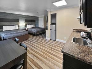 克洛维斯Rodeo Lodge的酒店客房带两张床和厨房