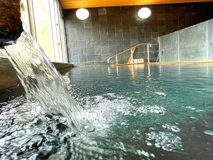 ObamaJisco Hotel Obama Onsen的游泳池中的喷泉,带滑梯