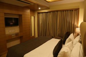 MundraThe Fern Residency Mundra的酒店客房,配有床和电视