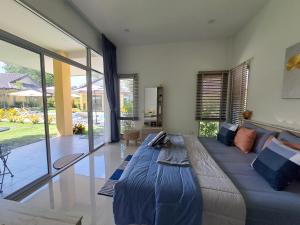 Ban ChamrungPool Villa, Resort, Mae Ramphueng Beach, Ban Phe, Rayong, Residence M Thailand的客厅设有一张大床和一个大窗户