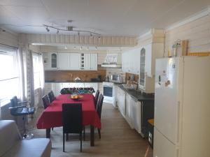 高尔Holiday Home的厨房配有红色的桌椅和冰箱。