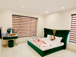 岑山Villa FLC Sam Son Lavender的一间卧室配有一张绿色的床和一张书桌