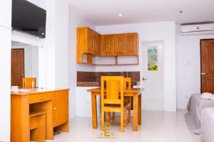 阿拉米诺斯Empress Island Hotel的厨房配有木制橱柜和桌椅