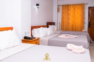 阿拉米诺斯Empress Island Hotel的两张位于酒店客房的床,配有毛巾