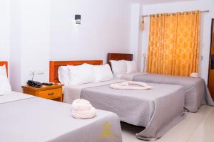 阿拉米诺斯Empress Island Hotel的酒店客房,配有两张带毛巾的床