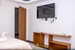 阿拉米诺斯Empress Island Hotel的卧室设有壁挂式电视和床。
